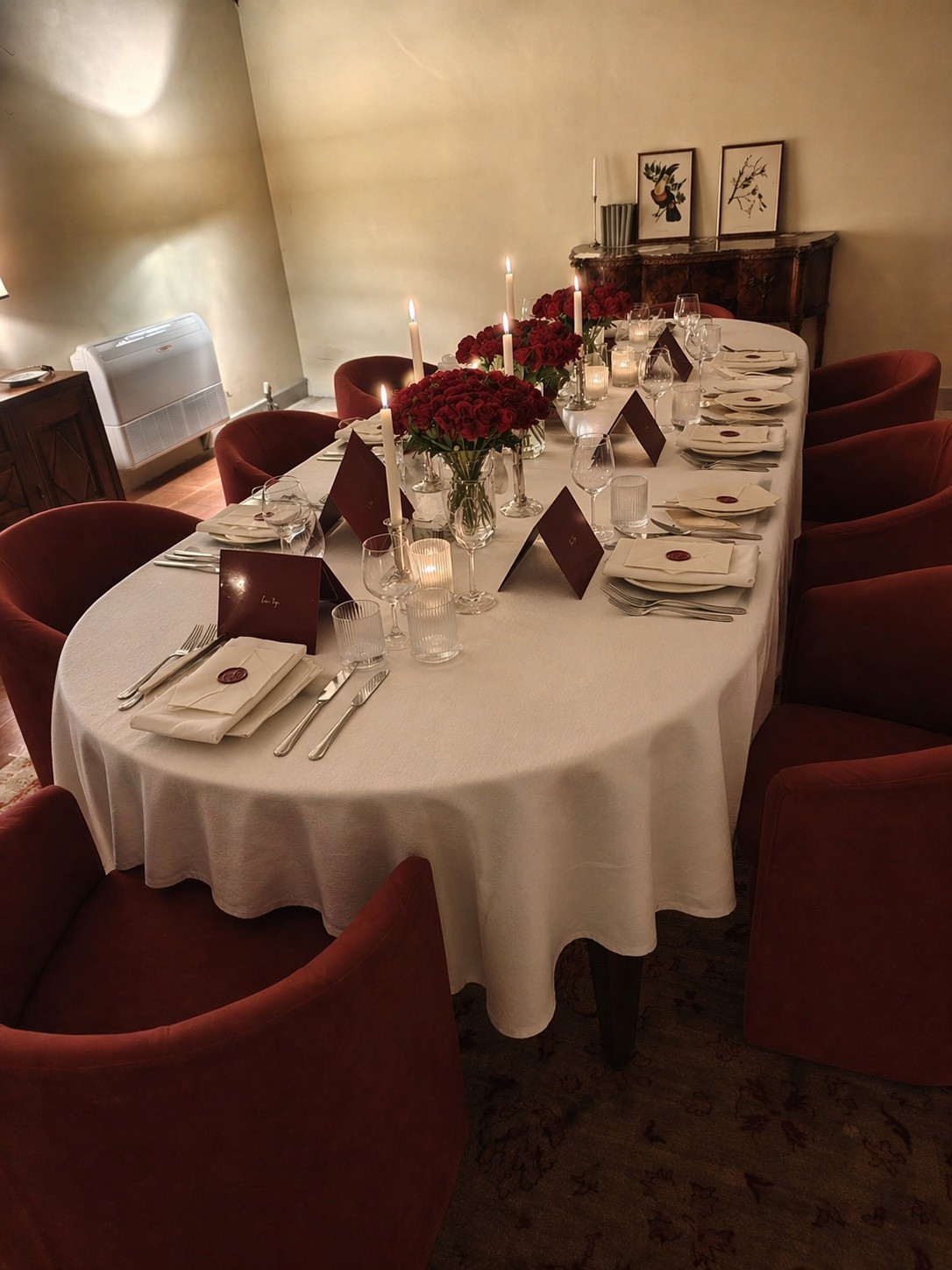 Tavola elegante con rose bordeaux, candele e mise en place Syntonia